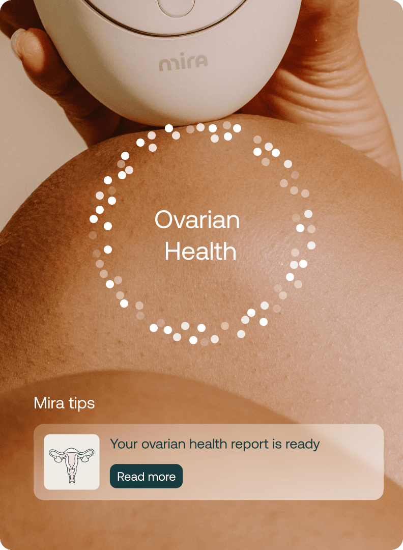Mira Ultra4 fertility monitor held over abdomen with ovarian health tracking screen and report notification