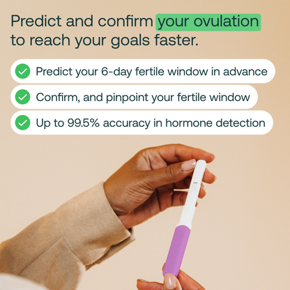 White and purple ovulation test wand held in hand against beige background.