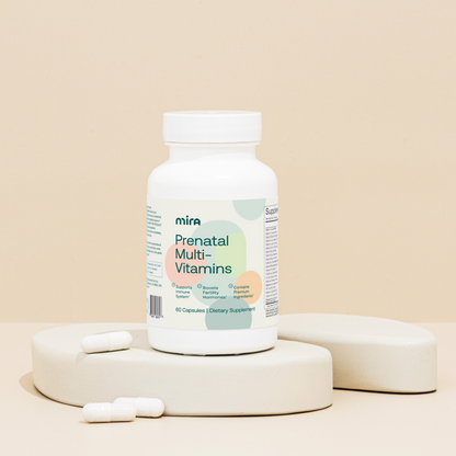 White bottle of Mira Prenatal Multi-Vitamins with white capsules displayed on a beige platform.