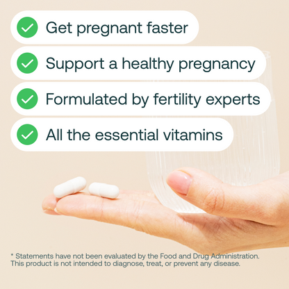White oval prenatal vitamin capsules resting in an open palm against a beige background.