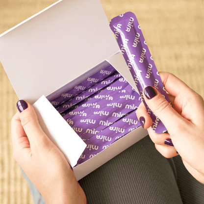 Purple fertility test wands with "mira" branding arranged in white box packaging.