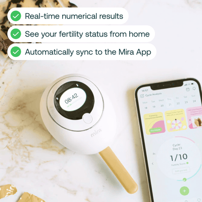 White and black handheld fertility wand with digital display next to smartphone showing Mira app interface.