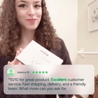Woman holding white Mira Fertility Max box with x20 count visible.