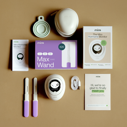Mira Hormone Monitor Max Kit contents including device, wand, test strips, charging case, and instructional materials arrange