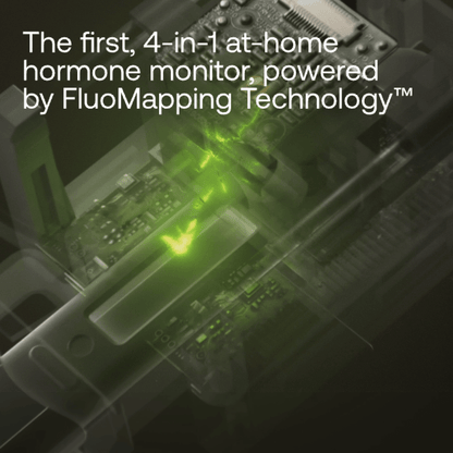 Handheld hormone monitor device with green fluorescent display and internal circuitry visible through translucent casing.