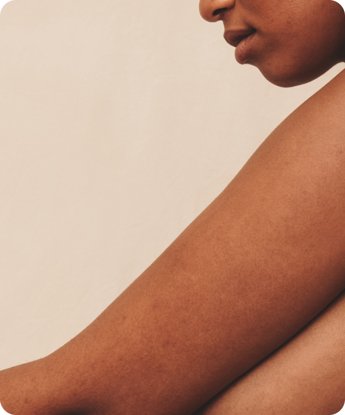Close-up of a woman's bare shoulder and back against a neutral background, representing women's health and body wellness