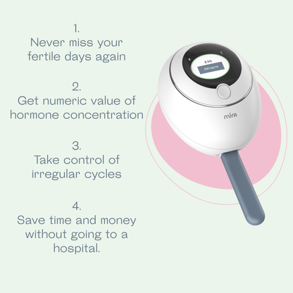 White and black handheld fertility tracker with digital display and gray handle on pink circular base.